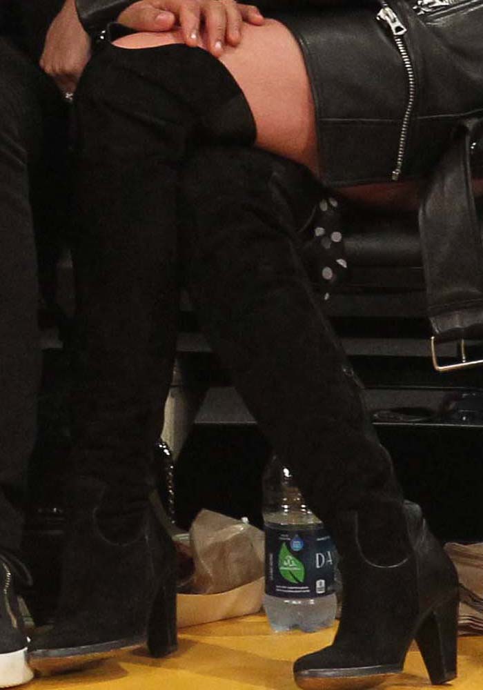 Chrissy Teigen shows off her black over-the-knee Chloé boots, featuring a suede shaft, textured leather panels, and a sturdy block heel