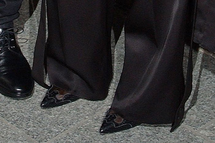 A closer look reveals the Givenchy “Rima” pumps peeking beneath the hem—pointed toes and brogue detailing subtly anchoring the look with tailored precision