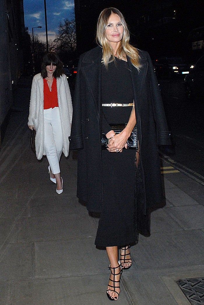 The sleek belt accentuates her waist, while a draped coat adds effortless sophistication as Elle Macpherson arrives at a London hotel