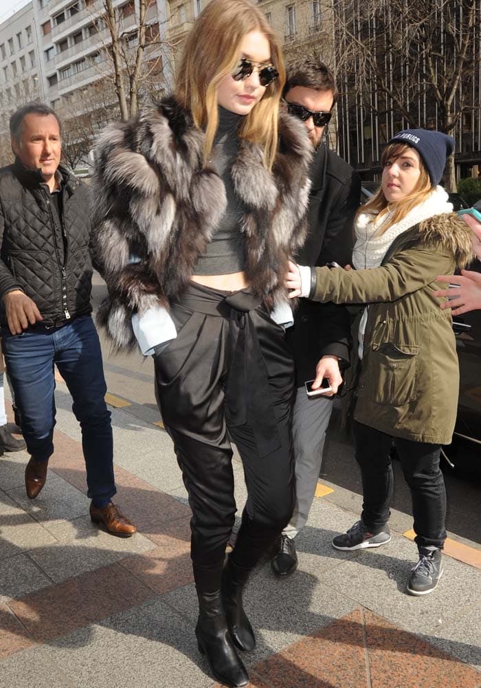 Gigi Hadid channels Parisian model-off-duty polish in a gray fur Waldrip coat, cropped turtleneck, and loose black trousers while arriving at the Four Seasons George V Hotel during Paris Fashion Week 2016