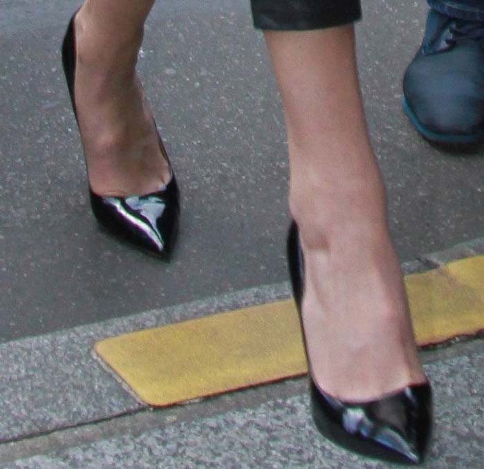 A close look at Gigi Hadid's patent Kurt Geiger "Britton" pumps, distinguished by their sharply pointed toes and sculptural metal heels that turned a classic black court shoe into a standout fashion-week statement