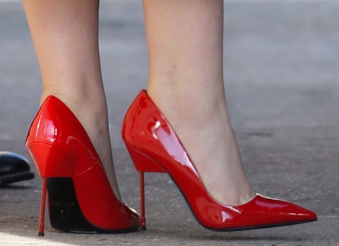 Ginnifer Goodwin steps out in bold red Kurt Geiger “Britton” pumps, featuring glossy patent leather and the brand’s signature razor-sharp metal stiletto heel for a striking finish