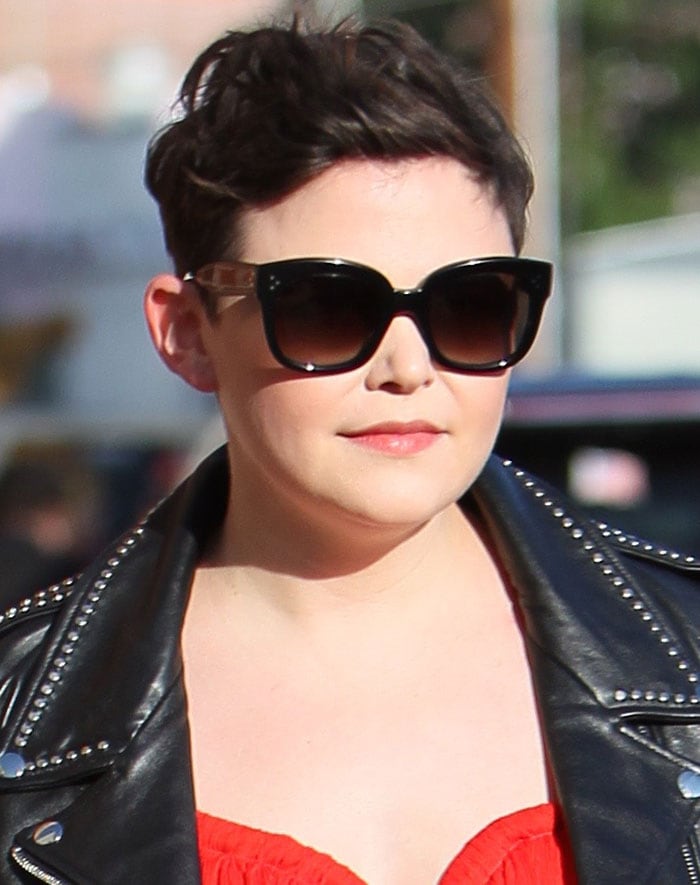 Ginnifer Goodwin adds a touch of Hollywood glam by hiding her eyes behind oversized black sunglasses, perfectly complementing her edgy leather jacket and red dress