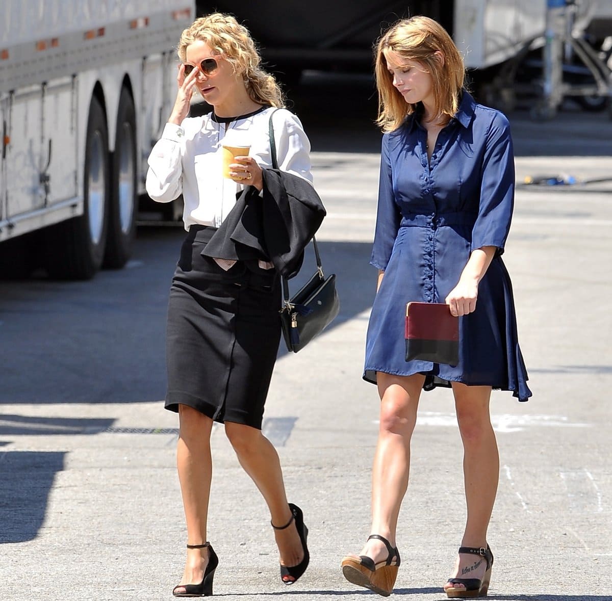 Ashley Greene and Kate Hudson are photographed on set of Wish I Was Here (2014), with Greene opting for cork-platform ankle-strap sandals while Hudson chooses sleek black open-toe heels—two grounded footwear choices that mirror their characters’ contrasting personalities