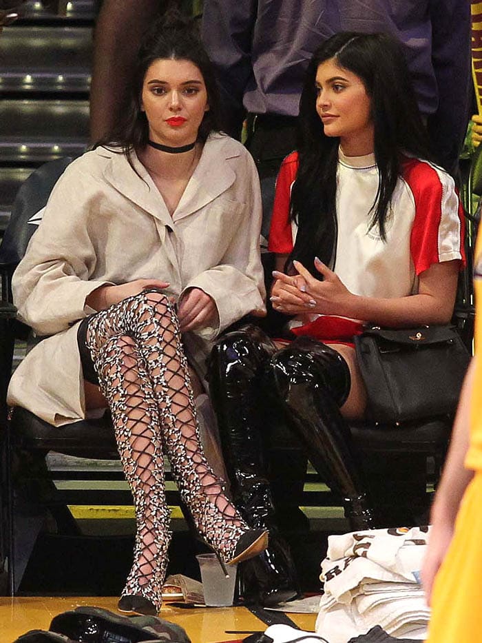 Kylie Jenner rocking a red-and-white Opening Ceremony bonsai-embroidered silk-satin dress, Kurt Geiger Wolf patent boots, and a chic Hermès Kelly bag