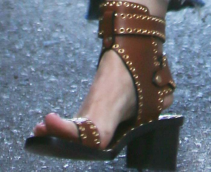 A close-up of Kristen Bell’s feet in Isabel Marant “Jaeryn” eyelet gladiator sandals, featuring studded leather straps and a chunky block heel