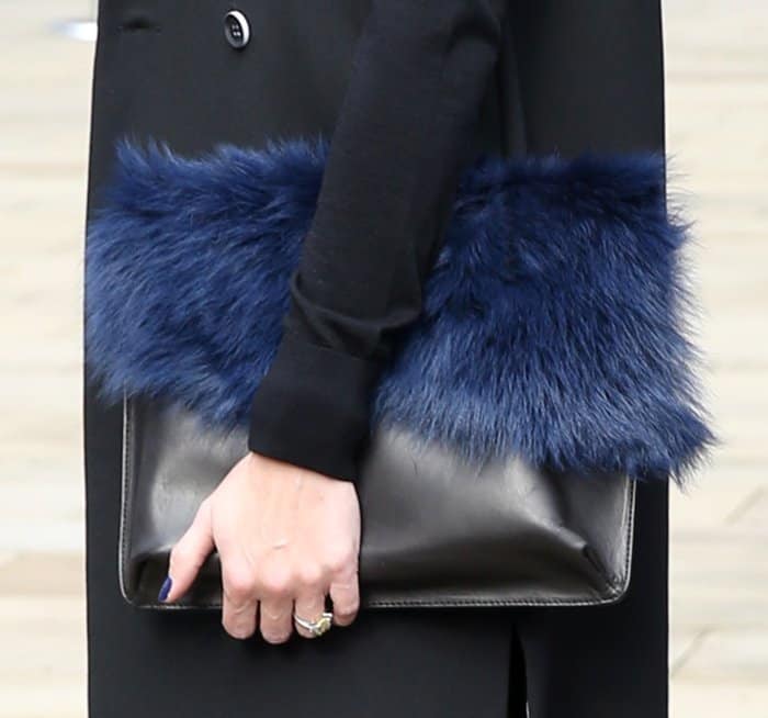 Olivia Palermo carries a chic black leather clutch with bold navy fur trim