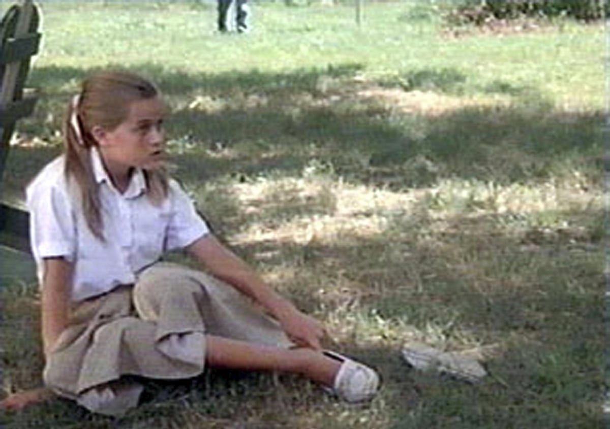 Reese Witherspoon, as young Dani Trant in The Man in the Moon, wears a crisp white blouse, khaki culottes, and simple white slip-on shoes that reflect her tomboyish Southern charm