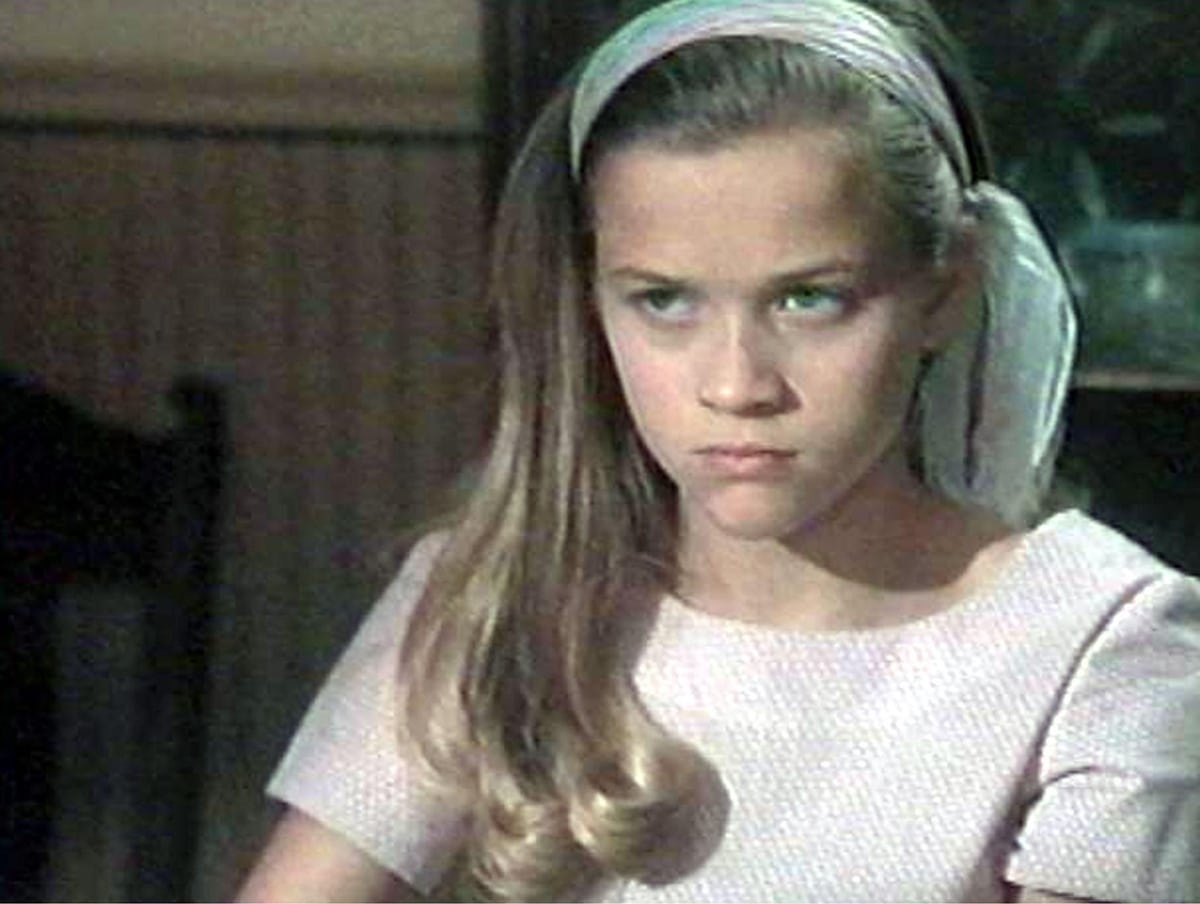 Reese Witherspoon channels youthful elegance as Dani Trant in The Man in the Moon, wearing a textured blush pink dress with a matching headscarf tied over her long curls