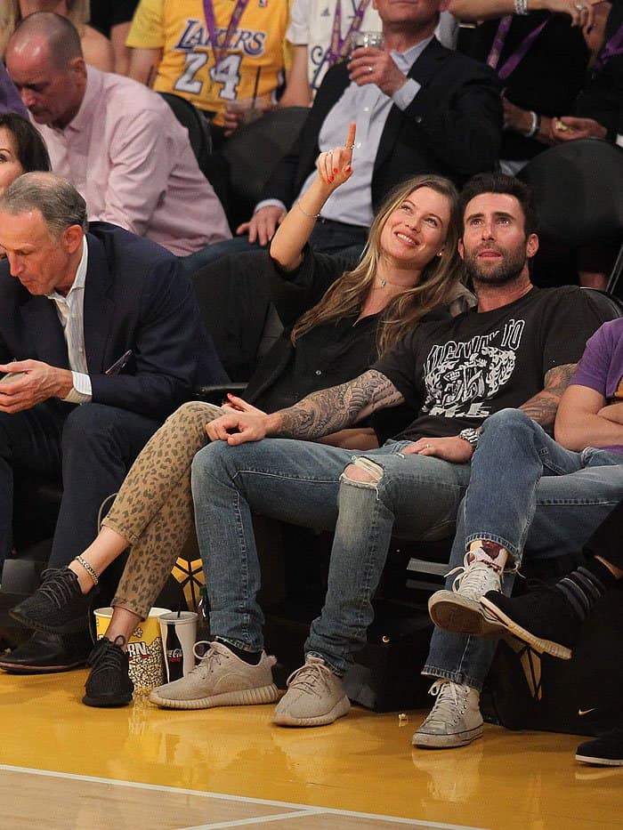 Behati Prinsloo keeps it casual and chic in leopard-print skinnies and Yeezy sneakers while enjoying a Lakers game with Adam Levine