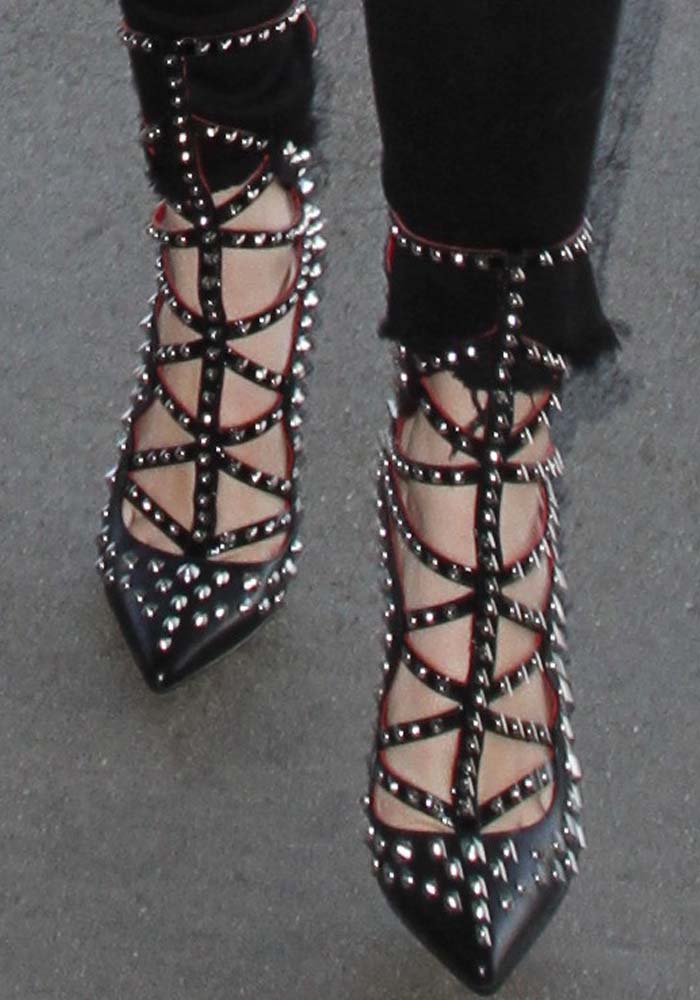 Bella Thorne makes a bold statement in studded black heels featuring intricate strappy details and sharp pointed toes