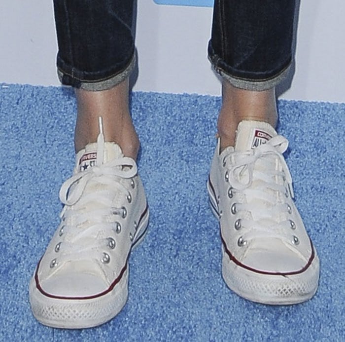 Charlize Theron keeps it casual in classic white Converse Chuck Taylor All Star sneakers, pairing the laid-back staple with cuffed jeans for an effortless off-duty look