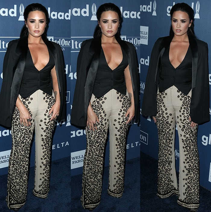 The singer's combination of structured tailoring, dramatic neckline, and flared cheetah-print trousers created one of the evening's most memorable fashion moments