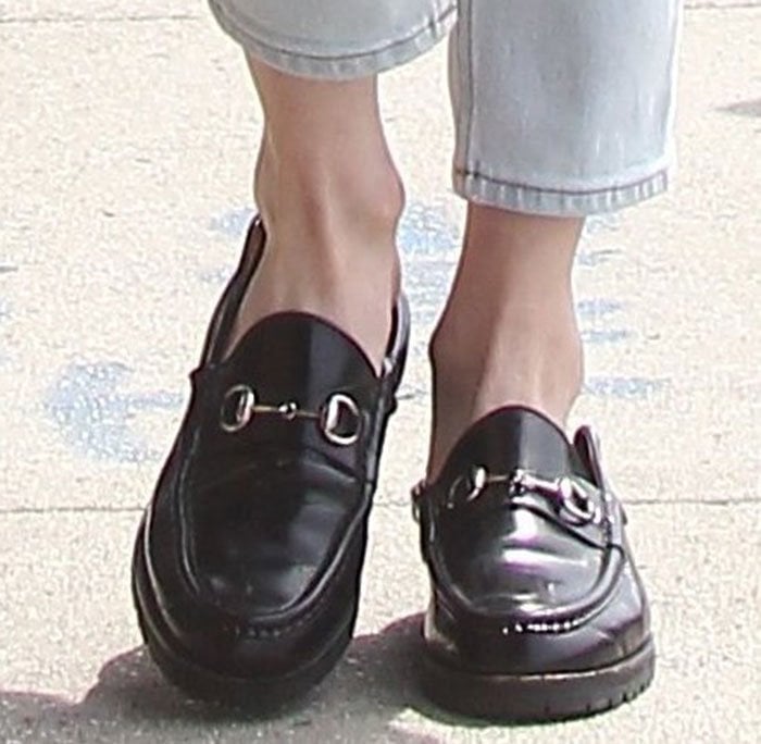 Emma Roberts grounds her off-duty look with black Gucci Horsebit loafers, their polished leather finish and signature metal hardware adding a refined, androgynous edge to cropped denim