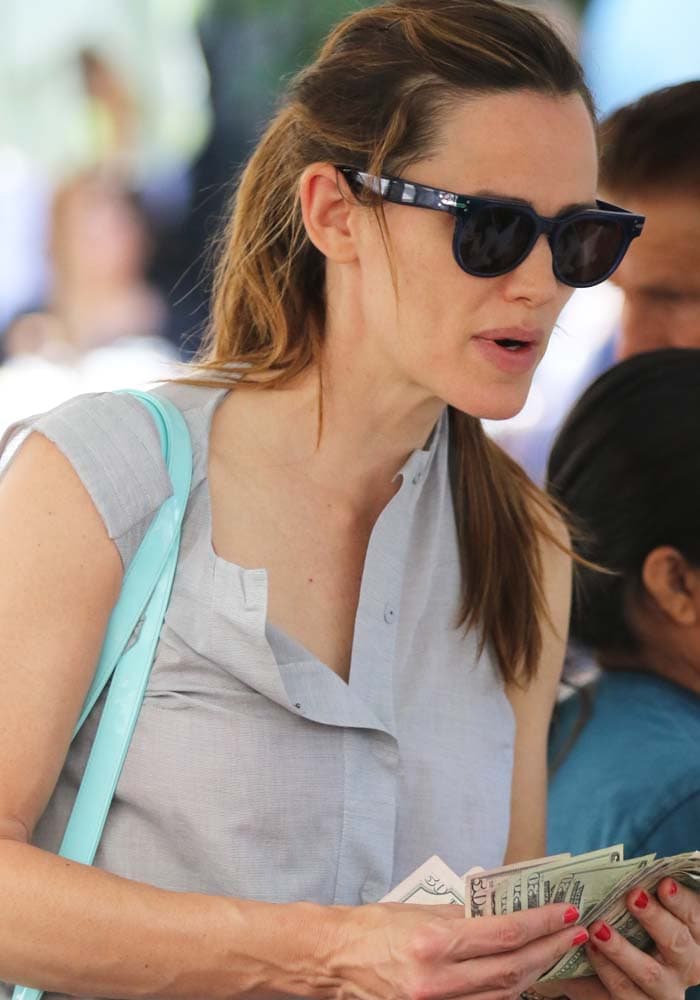 Jennifer Garner holds a wad of dollar bills as she shops at the Farmers Market