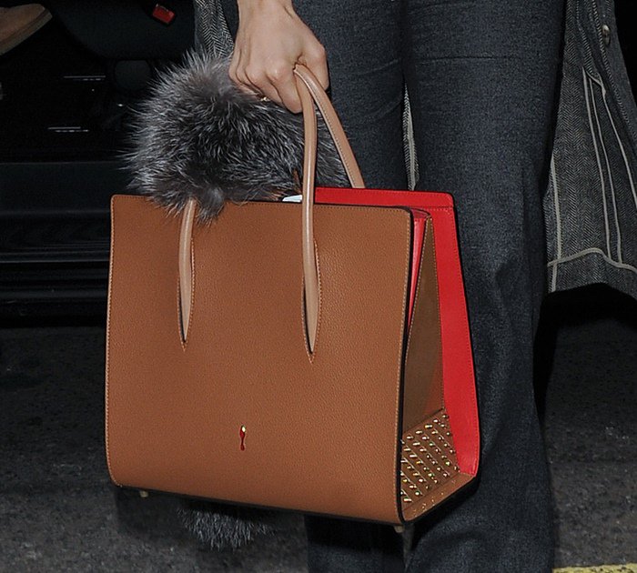 Jennifer Lopez adds a luxe touch to her travel look with the Christian Louboutin Paloma tote in noisette calfskin, featuring signature red siding and gold spike embellishments
