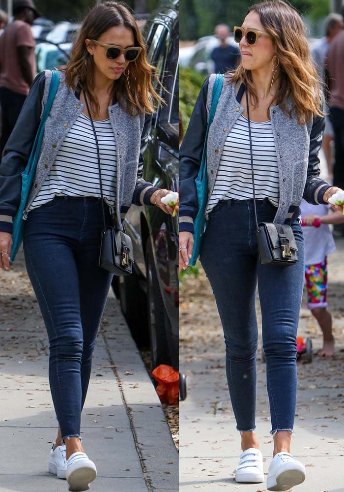 Jessica Alba keeps it effortlessly chic in a striped tee, fitted skinny jeans, and a varsity-inspired Rachel Zoe jacket, finishing the look with white Kenneth Cole “Kingvel” velcro sneakers and oversized sunglasses