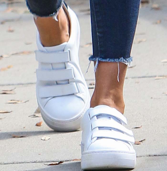 Close-up of Jessica Alba’s white Kenneth Cole “Kingvel” velcro sneakers, styled with frayed-hem skinny jeans