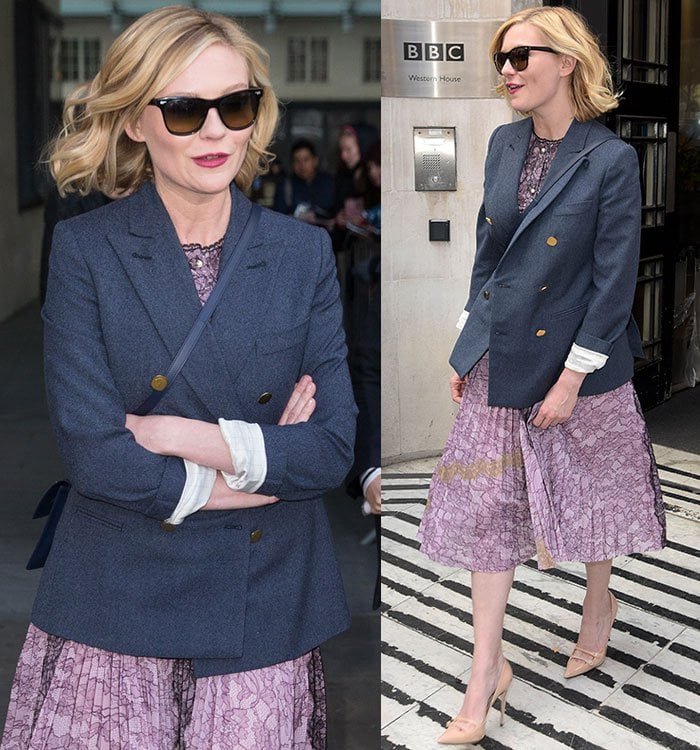 Kirsten Dunst wearing a lilac lace Gucci dress layered under a structured navy blazer, finished with nude patent pumps that subtly elongate her silhouette.