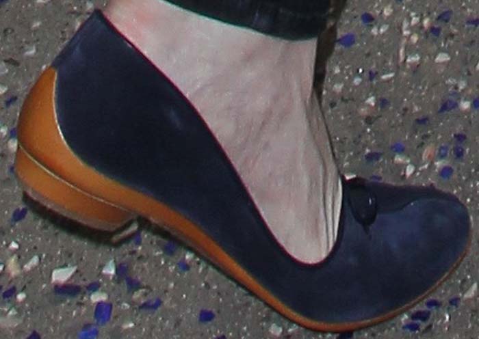 Her navy suede Ferragamo flats, finished with a bow detail and cognac heel, ground the look in quiet luxury while prioritizing comfort for travel