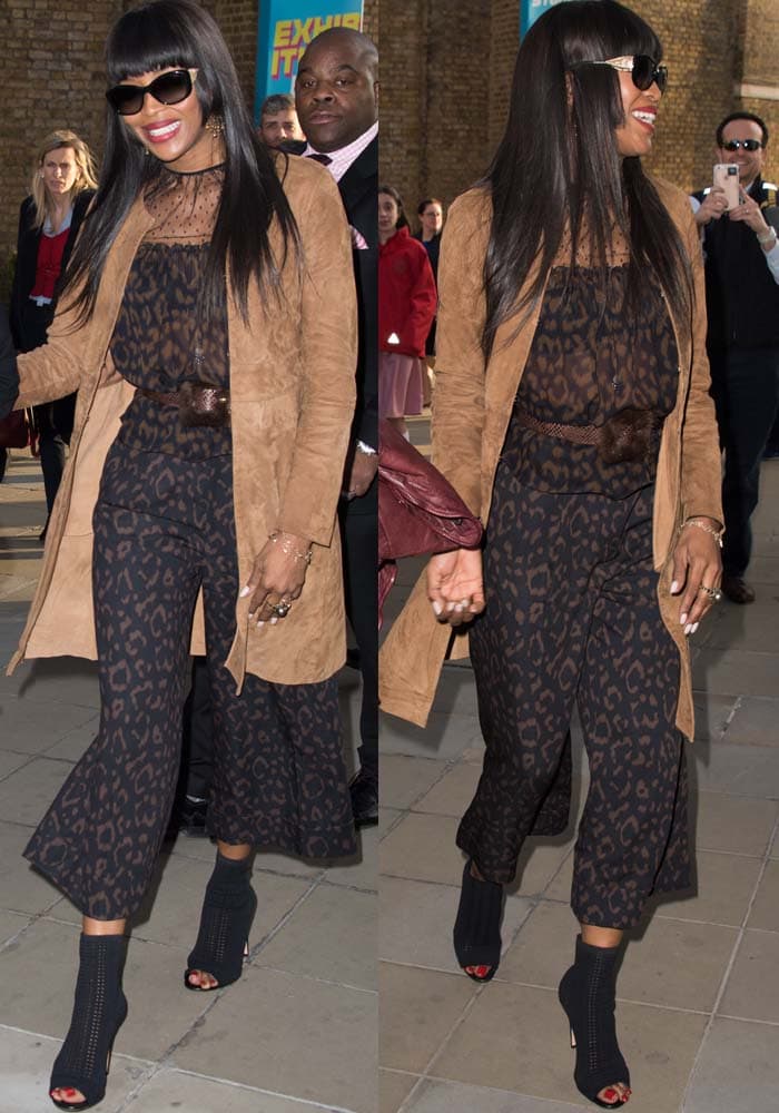 Naomi Campbell pairs a sheer leopard-print culotte jumpsuit with a tan suede coat and black peep-toe Gianvito Rossi “Vires” ankle boots at her book signing at Taschen Bookstore in London