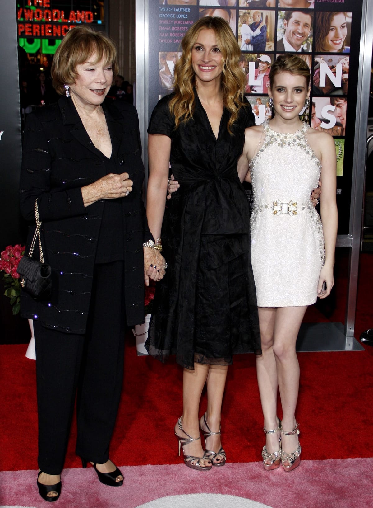 Shirley MacLaine, Julia Roberts, and Emma Roberts step out in coordinated red carpet elegance, with Emma finishing her embellished mini dress with metallic ankle-strap heels at the Valentine’s Day premiere in Hollywood