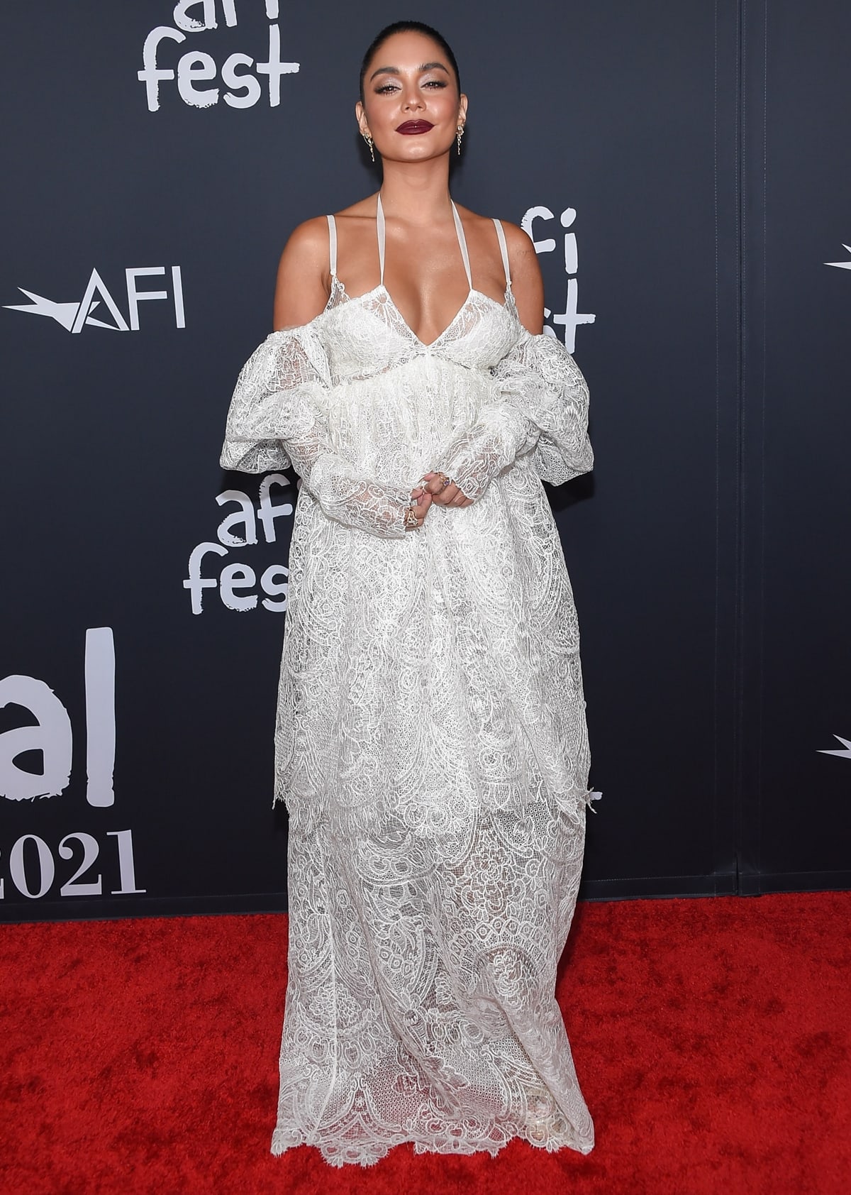 Vanessa Hudgens attended the AFI Fest premiere of Tick, Tick... Boom! in a bohemian-chic, tiered white lace gown from Vera Wang's Spring 2022 collection and waterfall earrings from SHAY Jewelry, with her shoes not visible in the photo