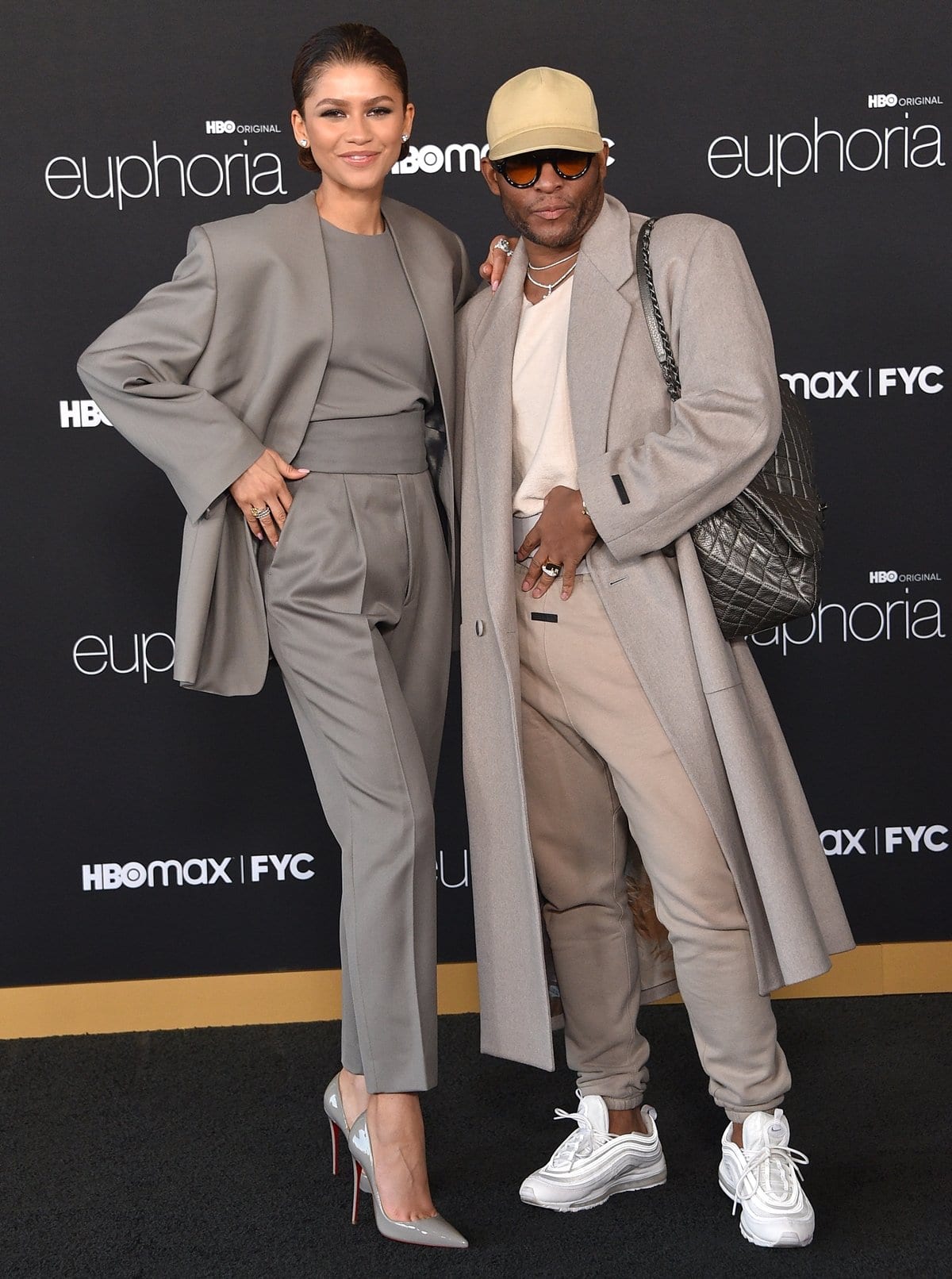 Zendaya delivers a lesson in modern tailoring in a sleek, monochrome Fear of God ensemble—pairing an oversized charcoal blazer with high-waisted, pleated trousers and glossy grey Christian Louboutin pumps—styled by Law Roach, who complements her look in tonal neutrals at the HBO Max Euphoria FYC event at the Academy Museum of Motion Pictures on April 20, 2022, in Los Angeles
