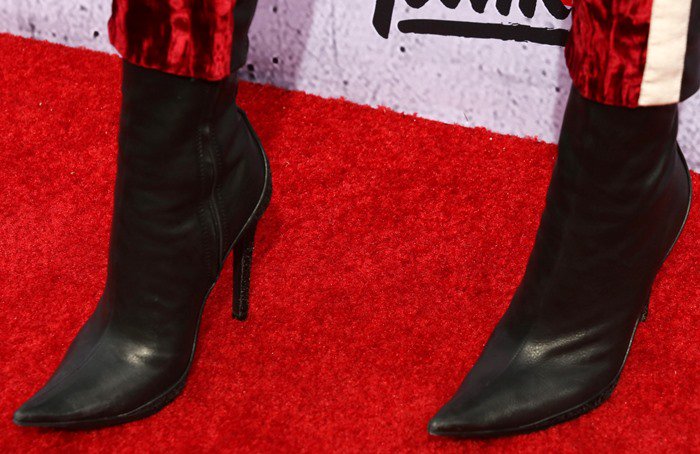 Zendaya completed her monochromatic Haider Ackermann look with matching black stretch-leather pointed-toe boots, reinforcing the sharp tailoring of her velvet suit