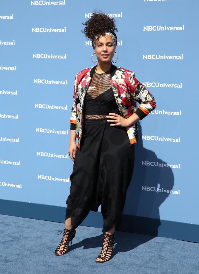 Alicia Keys poses on the blue carpet in polka-dot-printed harem pants and a colorful Dolce Gabbana bomber jacket