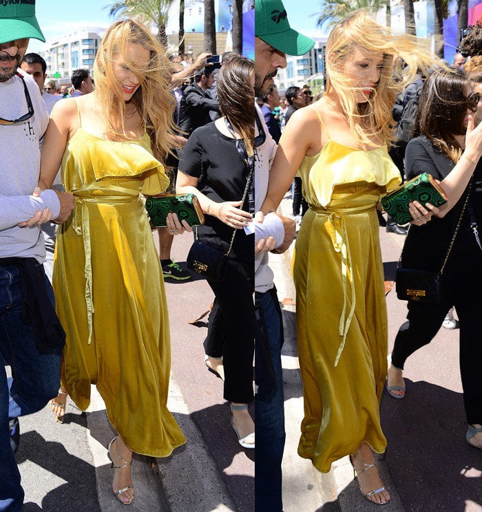 Blake Lively steps through the Cannes crowds in a flowing gold Valentino dress, her look finished with minimalist silver Jimmy Choo sandals that subtly peek out beneath the hem during the 2016 Cannes Film Festival