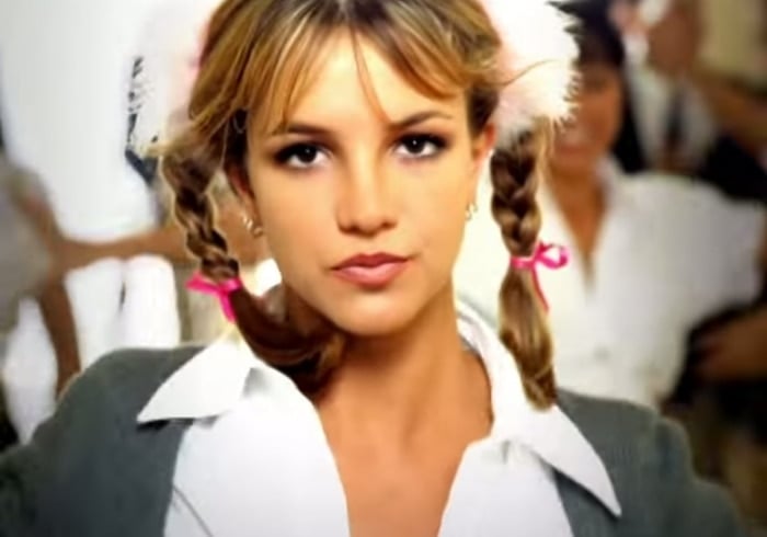 Britney Spears in her breakout role from the 1999 “…Baby One More Time” music video, wearing the now-iconic schoolgirl-inspired outfit that launched her pop superstardom and influenced Y2K fashion