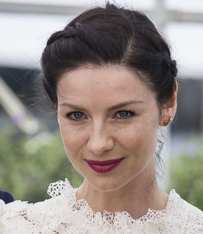 Caitriona Balfe showcases her elegant braided updo and bold plum lips at the 69th Cannes Film Festival
