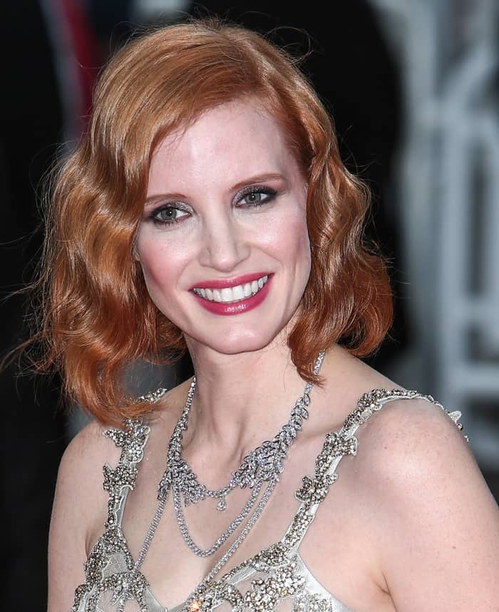 Facing the cameras, Jessica Chastain smiles as the layered diamond strands and sculptural detailing of her McQueen dress sparkle under the red-carpet lights
