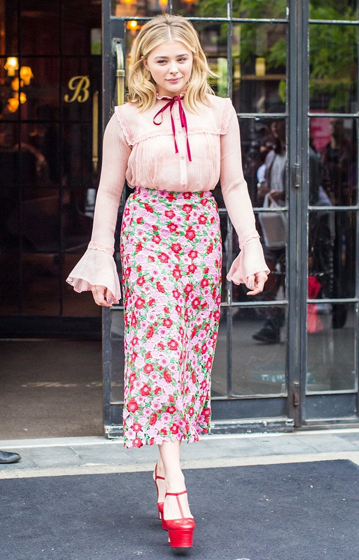 Chloë Grace Moretz steps out of The Bowery Hotel in a vintage-inspired Gucci Spring 2016 look featuring a pink lace blouse, floral skirt, and bold red platform heels