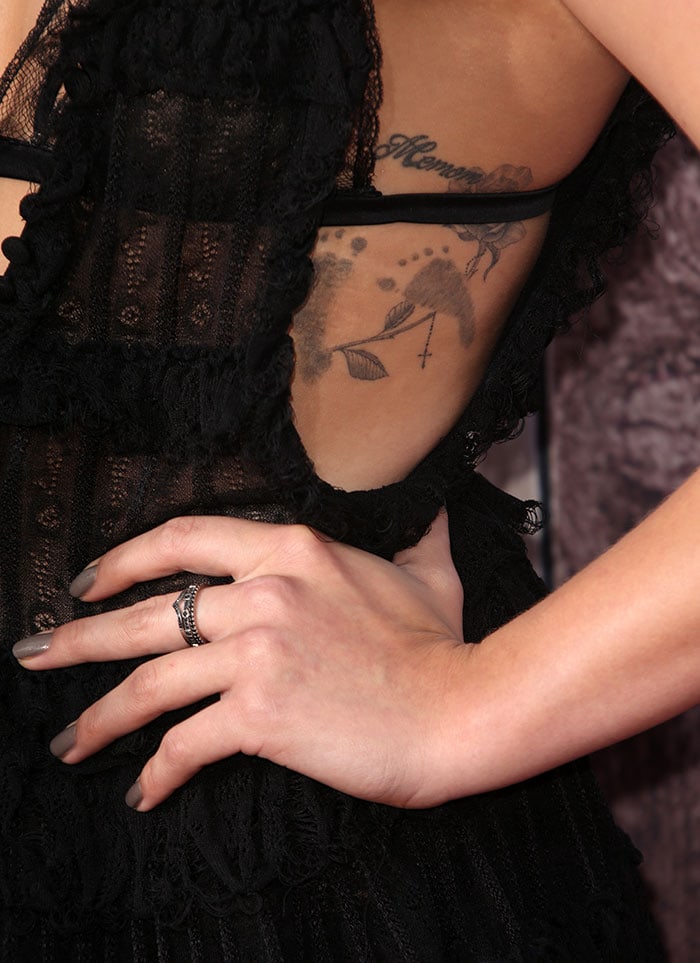 A closer look reveals Chloë’s intricate ribcage tattoos framed by the gown’s sheer lace panels and soft ruffled edges