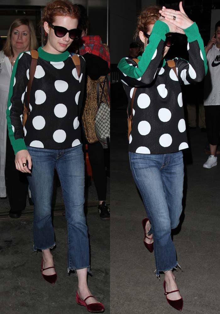Emma Roberts pairs a polka-dot Chris by Christopher Bu sweater with slightly flared Mother Insider crop jeans, grounding the look with rich red velvet Tabitha Simmons “Hermione” flats that add a refined, feminine finish