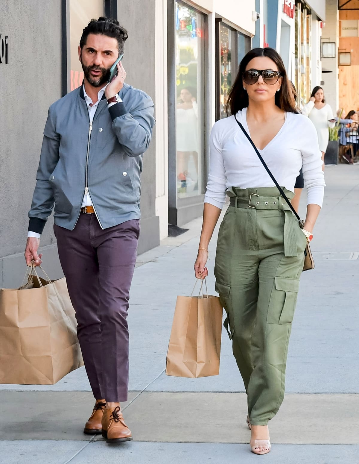 Eva Longoria, wearing Rag Bone Tilda cargo pants paired with a white blouse, Gianvito Rossi Lyn mules, and a Sabukana Loteria bag, and her husband José Bastón enjoy an afternoon of shopping