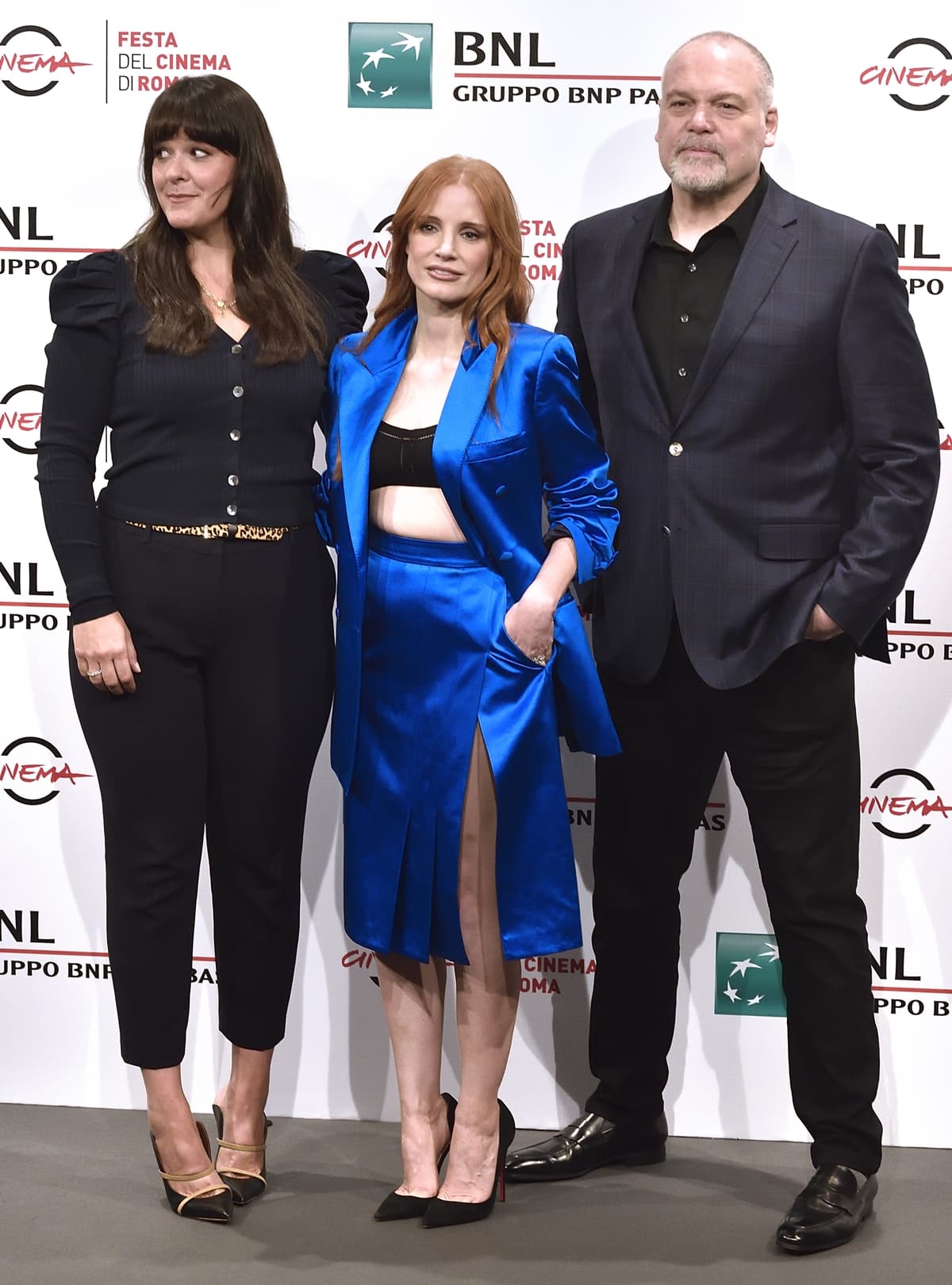 Jessica Chastain stands between producer Kelly Carmichael and Vincent D’Onofrio at the 2021 Rome Film Fest, grounding her vivid blue Gucci silk duchesse look with classic black Christian Louboutin Iriza pumps