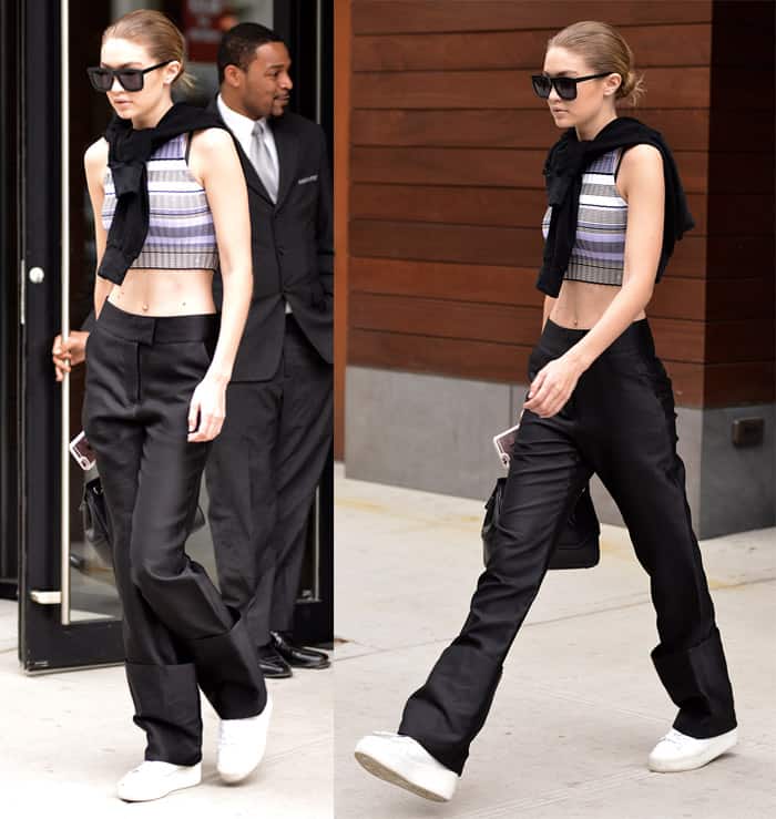 Gigi Hadid effortlessly pulls off a casual chic look, wearing rolled-up black pants with an Elizabeth James striped crop top and Ash platform sneakers in New York