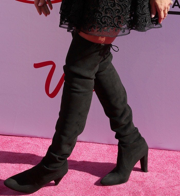 Jessica Alba showcases her sleek black Stuart Weitzman Highland over-the-knee boots, adding height and elongating her legs on the pink carpet