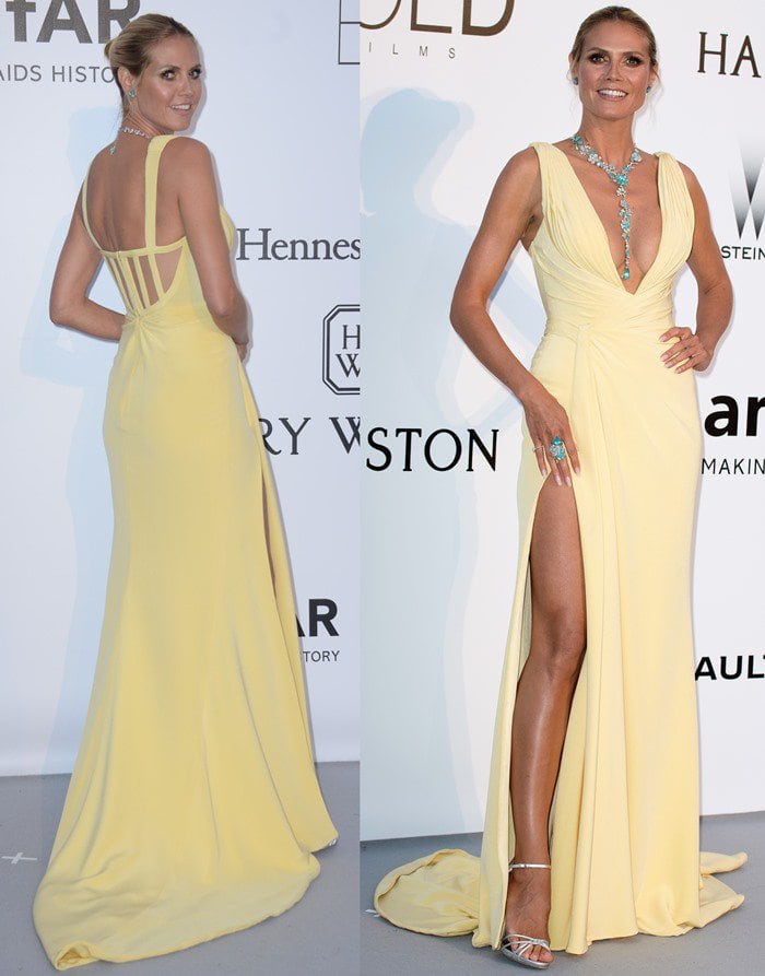 Heidi Klum commands attention in a sunlit yellow Versace gown, the plunging neckline and thigh-high slit showcasing her statuesque legs while maintaining an elegant, red carpet–ready silhouette
