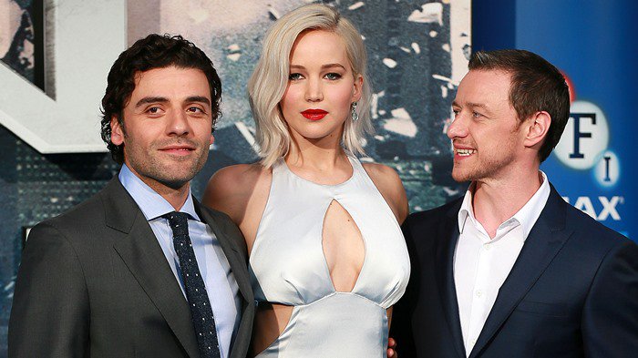 Jennifer Lawrence stuns in a pale silver satin gown with a keyhole neckline, standing between co-stars Óscar Isaac and James McAvoy at the X-Men: Apocalypse fan screening event