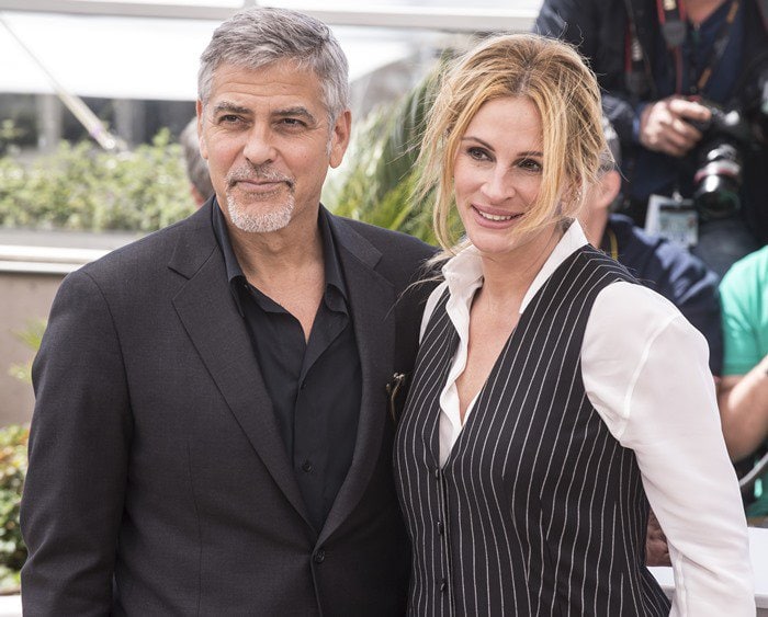 George Clooney and Julia Roberts pose together at the 2016 Cannes Film Festival, with Clooney in a classic black suit and Roberts in a black and white pinstripe Givenchy jumpsuit