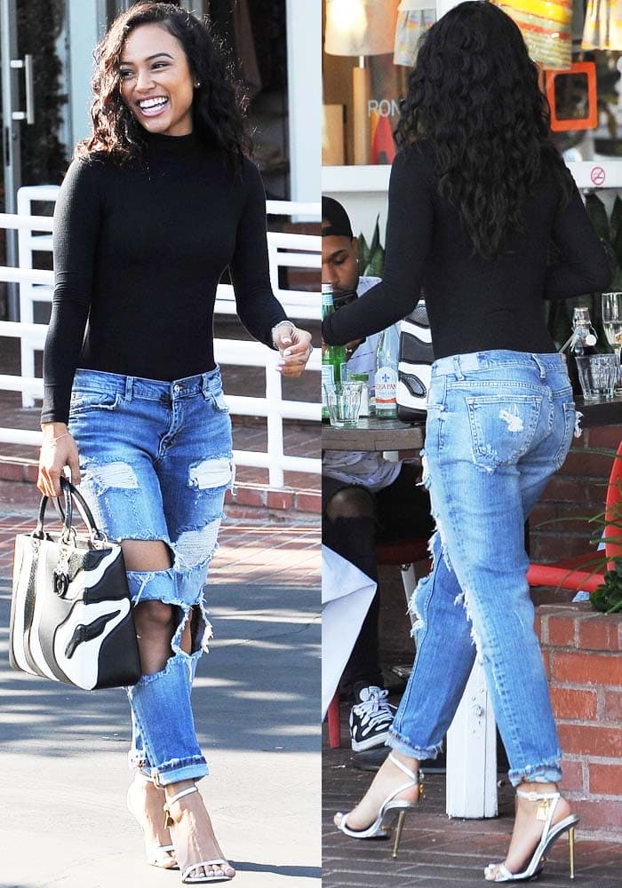 Karrueche Tran pairs a sleek black Topshop bodysuit with ripped Zara jeans, a black-and-white Dior “Lady Dior” tote, and silver Tom Ford padlock sandals for an elevated casual-chic lunch look