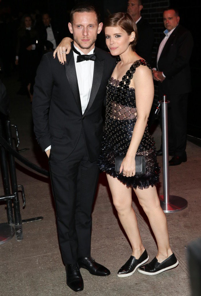 Kate Mara softens the futuristic edge of her embellished Paco Rabanne mini by swapping stilettos for black Miu Miu slip-on sneakers, adding a relaxed, off-duty contrast beside Jamie Bell at the Met Gala after-party