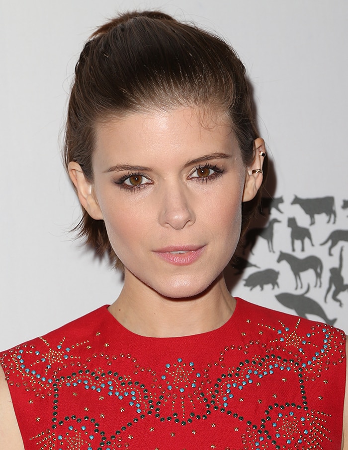 A softly swept-back hairstyle and natural makeup keep the focus on clean lines and the statement footwear below