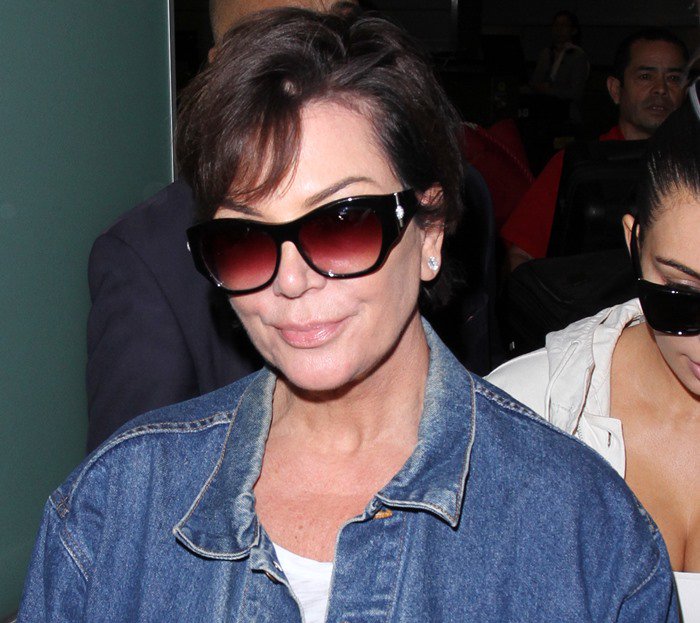 Kris adds a touch of glamour to her laid-back travel style with sleek gradient sunglasses that complement her minimalist denim-and-white outfit