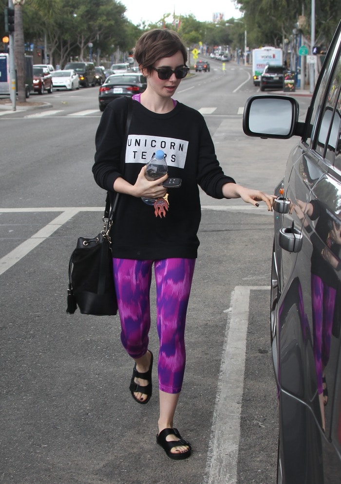 Lily Collins keeps it casual in vibrant purple leggings and classic black Birkenstock sandals while leaving Body by Simone in Los Angeles on May 8, 2015