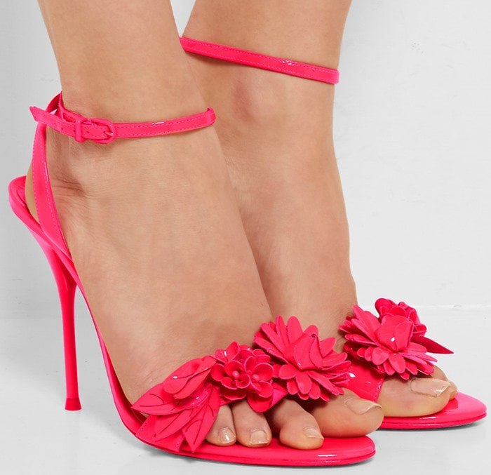 Sophia Webster’s signature ‘Lilico’ sandals are made from glossy patent leather and decorated with intricate floral appliqués across the slender toe strap